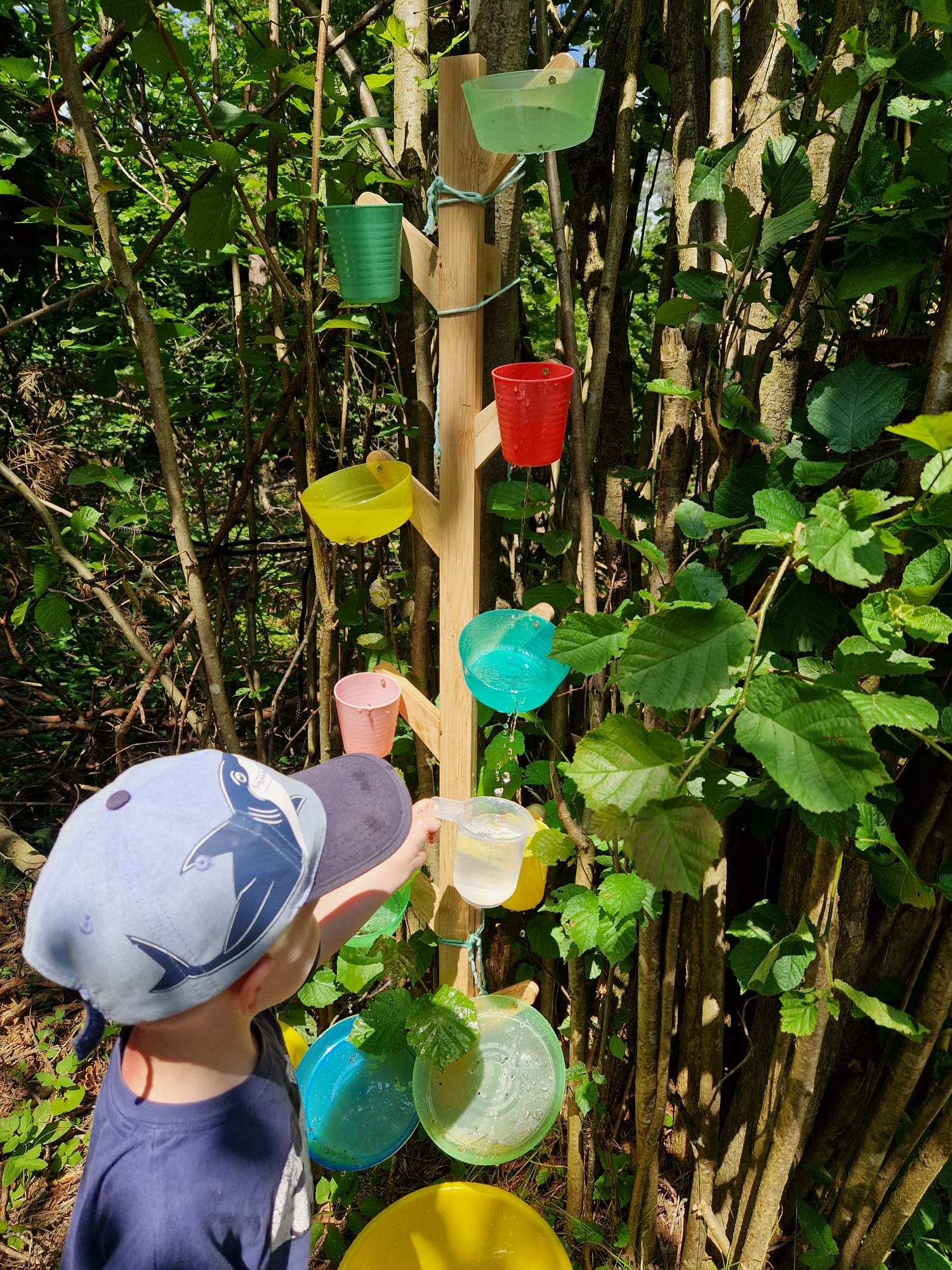 Kind entdeckt spielerisch Wasser und Natur im Wald